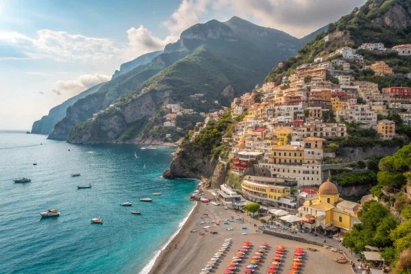 Positano Beach on the Amalfi Coast with pastel buildings, vibrant umbrellas, and the Mediterranean Sea